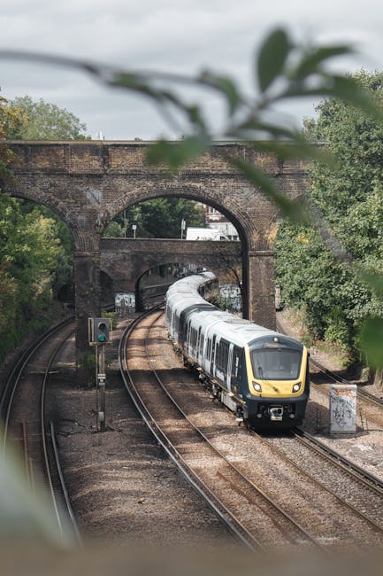 The image shows Finsbury Park railway station platform with a row of metal seating benches and a large overhead sign displaying the station name. The platform is covered by a metal roof supported by v